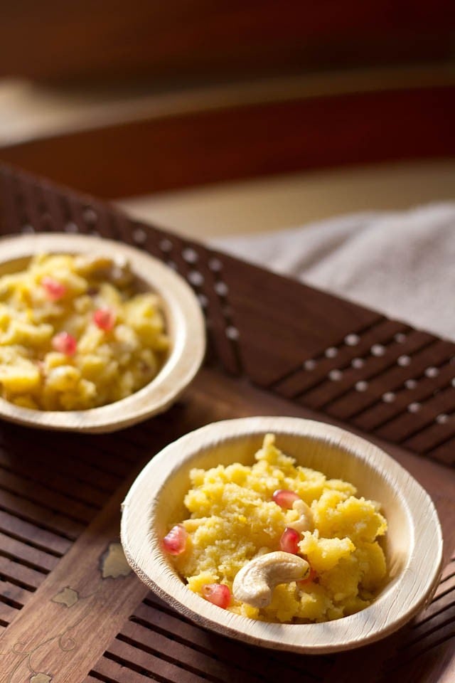 mango halwa in two areca leaf bowls on a brown wooden tray,