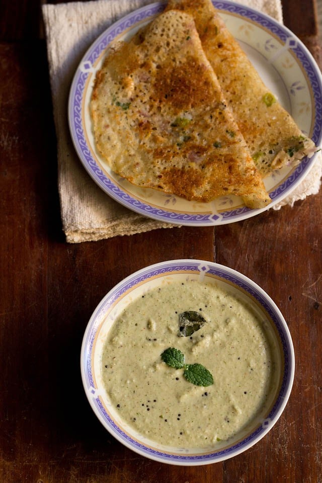 pudina pachadi served in a bowl with rava dosa on a plate