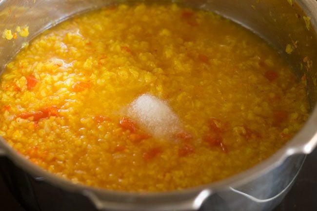 small mound of salt on cooked moong dal