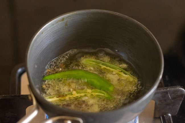 slit green chilies, garlic being fried in ghee.