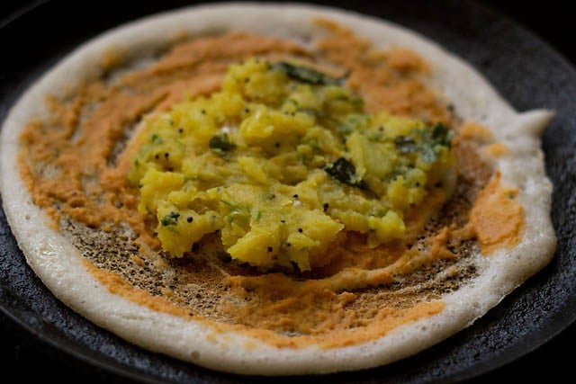 Spread the potato pariya filling over the chutney-coated dosa. 