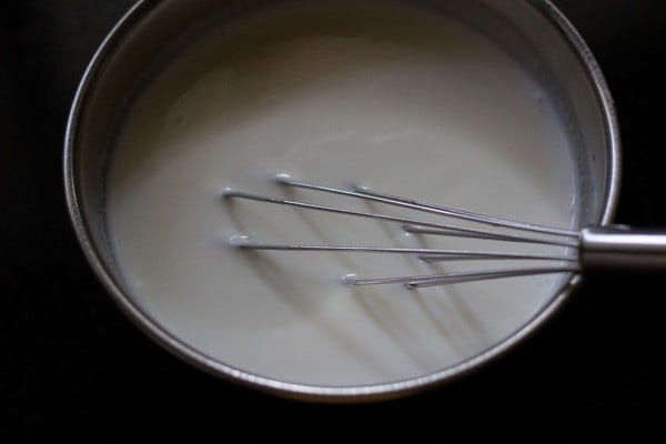 whisking curd for onion tomato raita