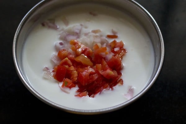 adding chopped tomatoes to curd or yogurt