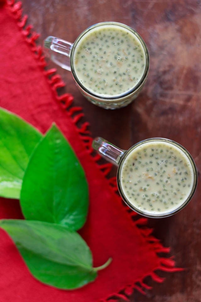 paan milkshake served in 2 glasses with fresh paan leaves kept on the left side. 