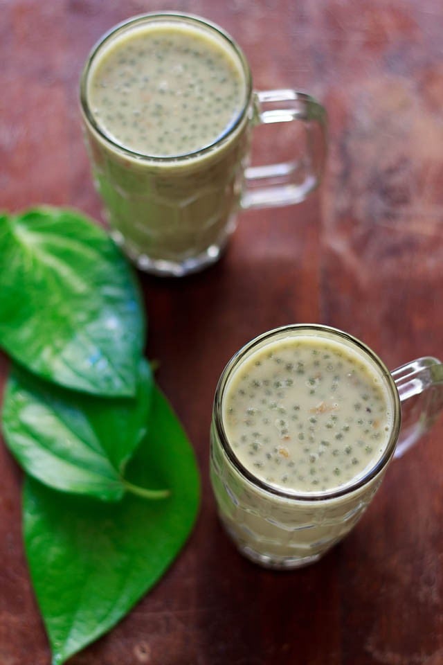 paan shots served in 2 glasses with fresh paan leaves kept on the left side. 