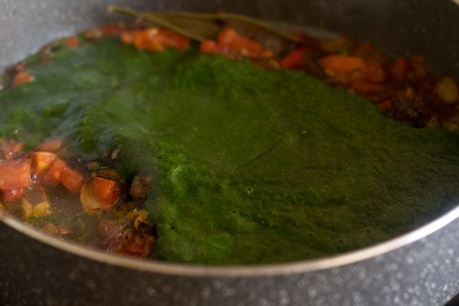 adding palak puree for palak biryani