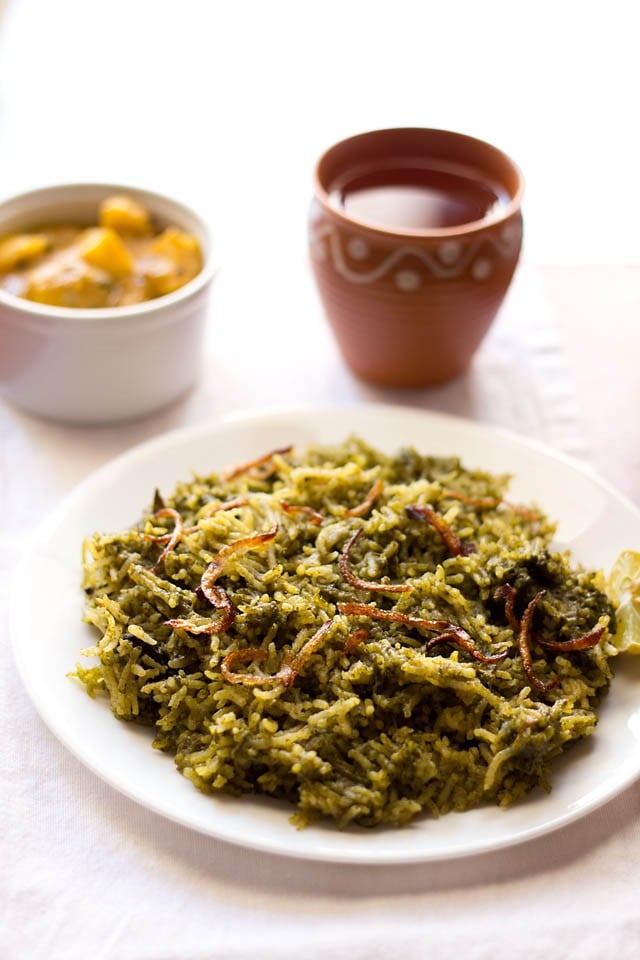 palak biryani served on a white plate.