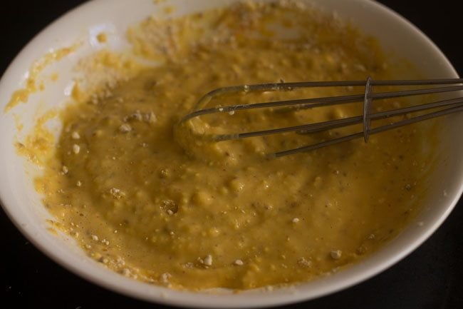 mixing the ingredients in the bowl with a wired whisk. 