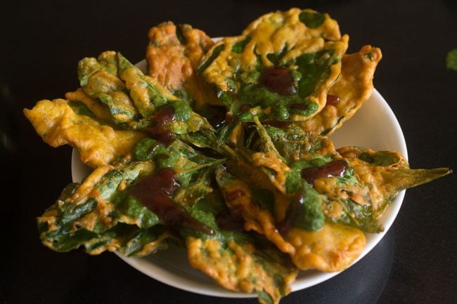 green chutney and sweet chutney added on top of palak patta pakodas. 