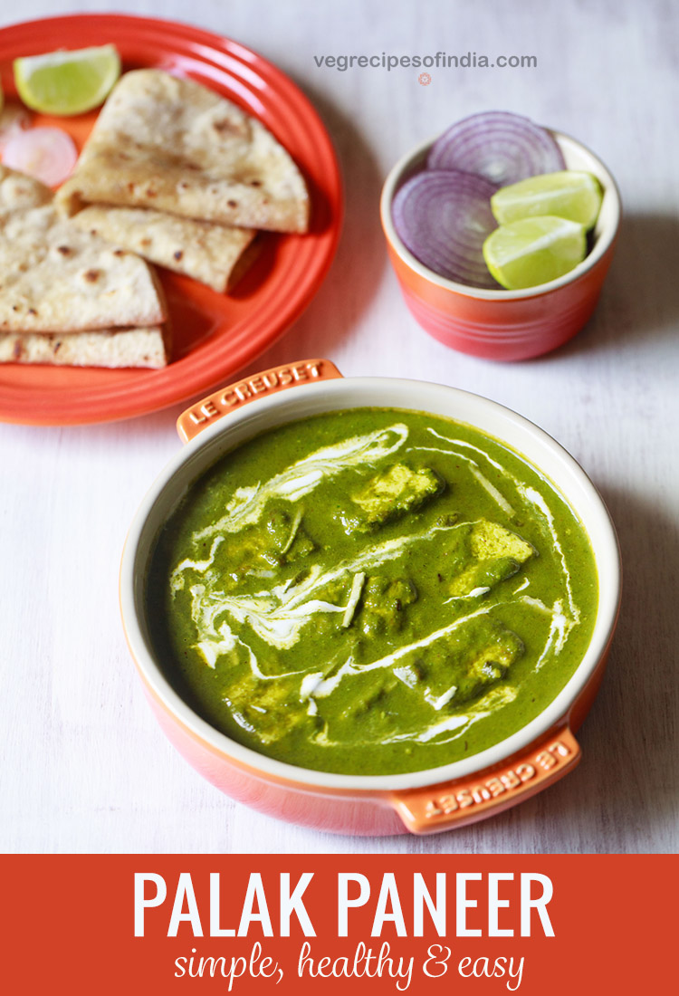 palak paneer topped with cream, garnished with ginger julienne and served in an orange bowl on a white board with roti kept on a dark orange plate on top left and a small orange bowl with round sliced onions and lemon wedges on top