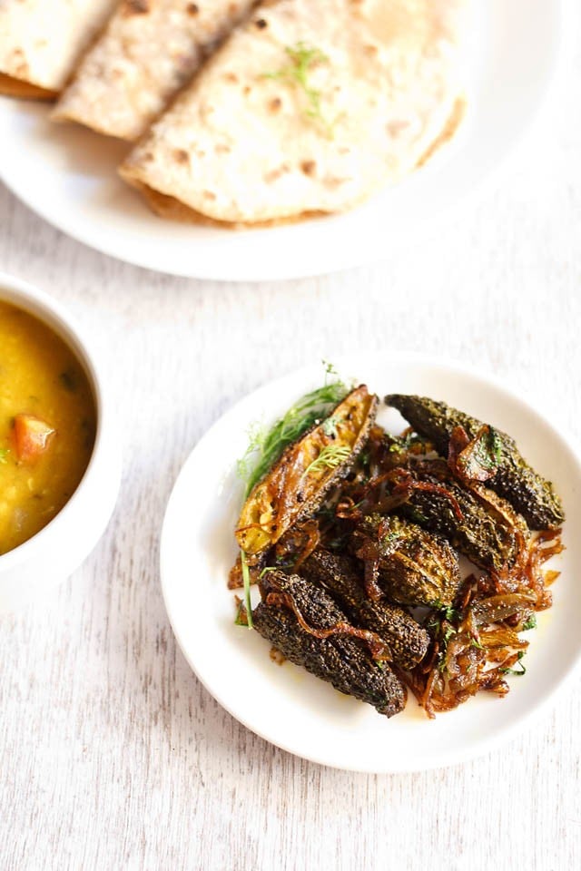 Punjabi bharwa karela served on a white plate with roti