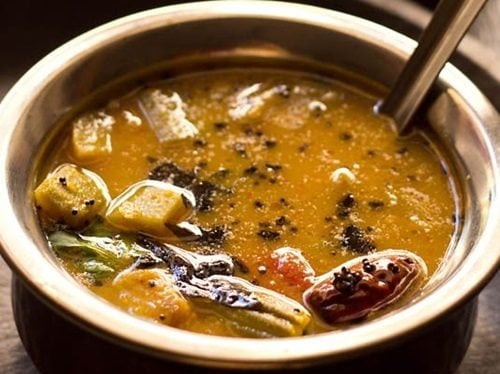 closeup shot of udupi sambar in a bowl with spoon