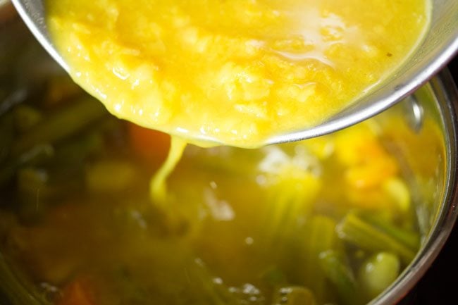 adding mashed dal to vegetables in pan for udupi sambar 