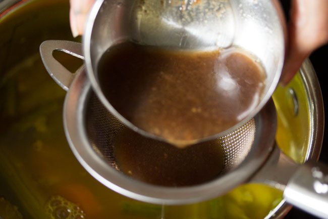 adding tamarind pulp to pan for udupi sambar 