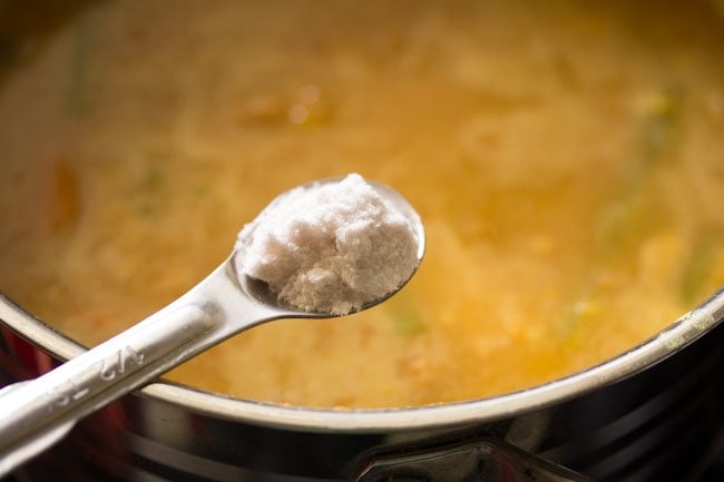 adding salt to udupi sambar in pan