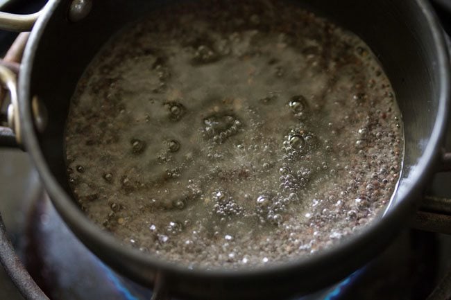 spluttering mustard seeds in hot oil for tempering of udupi sambar 