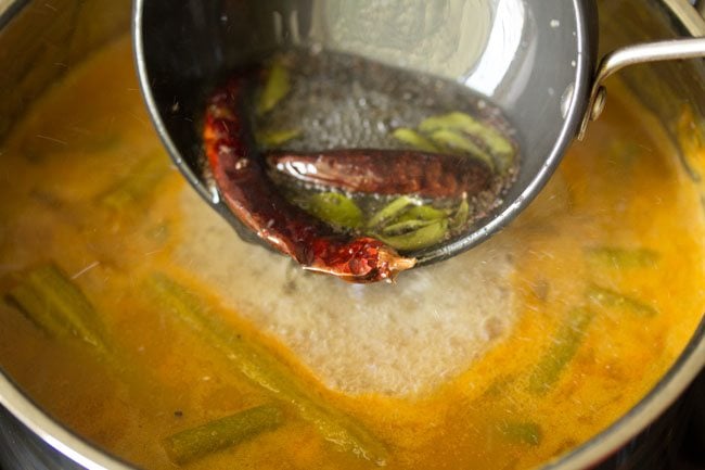 pouring the tempering in the udupi sambar 