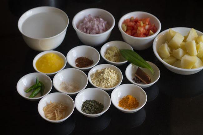ingredients for aloo palak prepped in white bowls