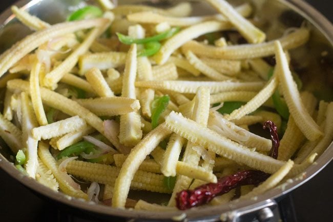 adding baby corn and sautéing it in pan