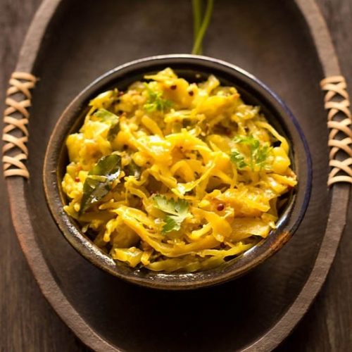 cabbage thoran in an dark earthen bowl