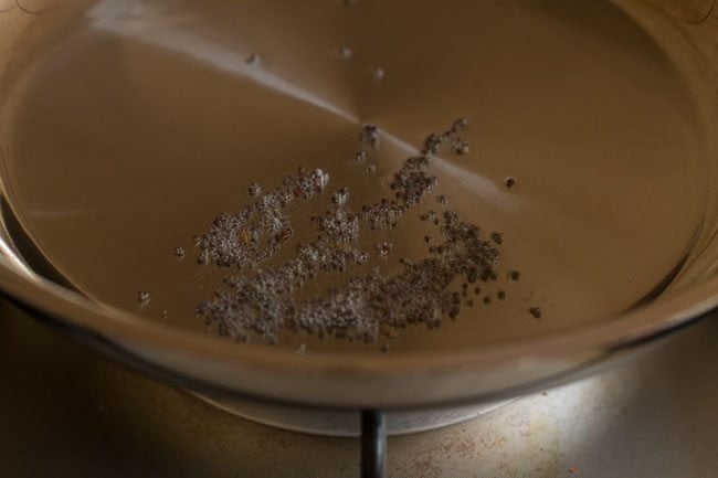 sautéing mustard seeds in hot oil in pan 