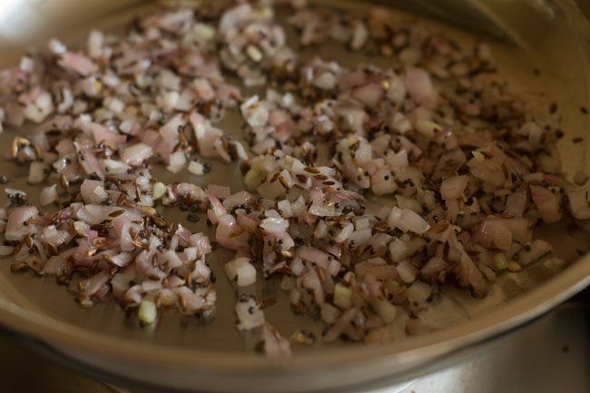 sautéing onion in hot oil to make cabbage thoran recipe