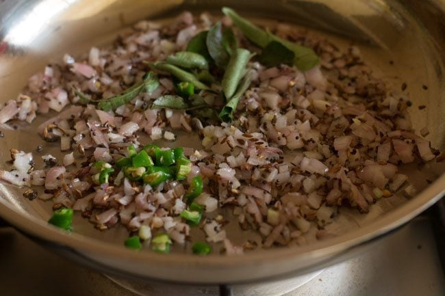 sautéing chopped green chili and curry leaves in pan