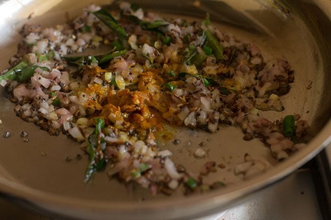 mixing turmeric powder and asafoetida in pan