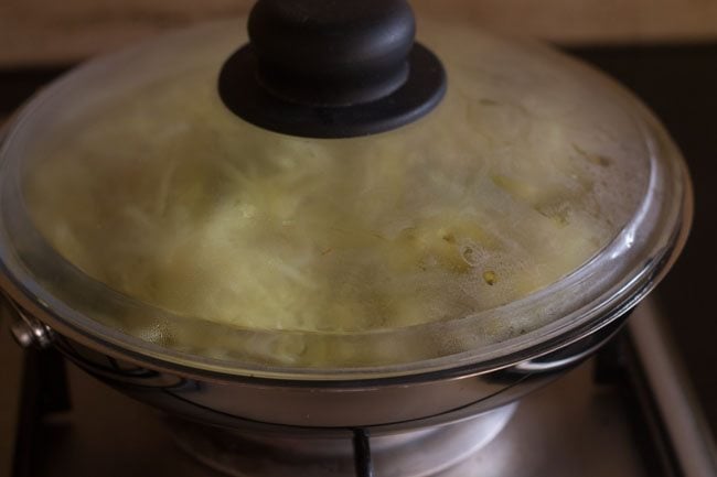 cooking cabbage in pan to make cabbage thoran recipe