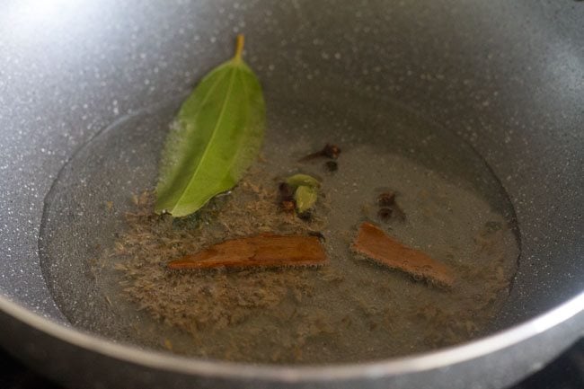 adding whole spices in hot oil. 