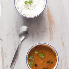 dal rasam served in a bowl with rice on side