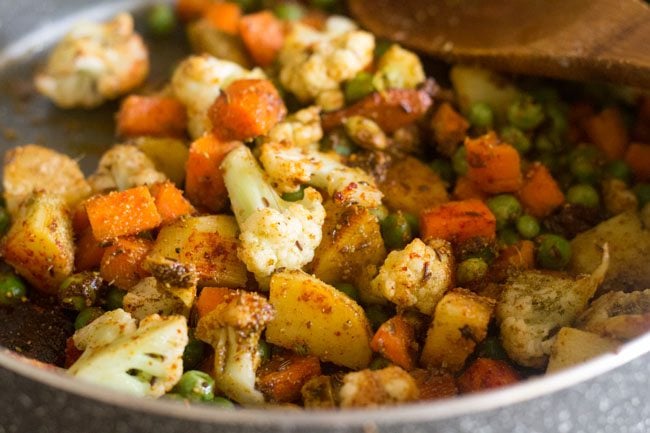 sautéing the spiced vegetables in the pan