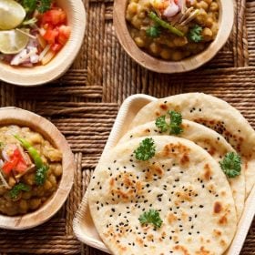 kulcha served in a square tray with a side of dried peas curry.