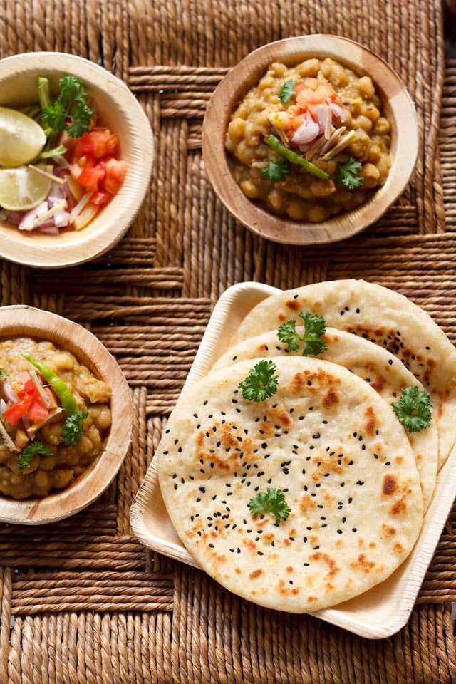 kulcha served in a square tray with a side of dried peas curry.