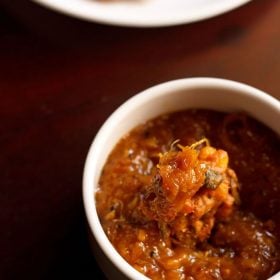 mango chutney in a white bowl with a pakora dipped inside the chutney