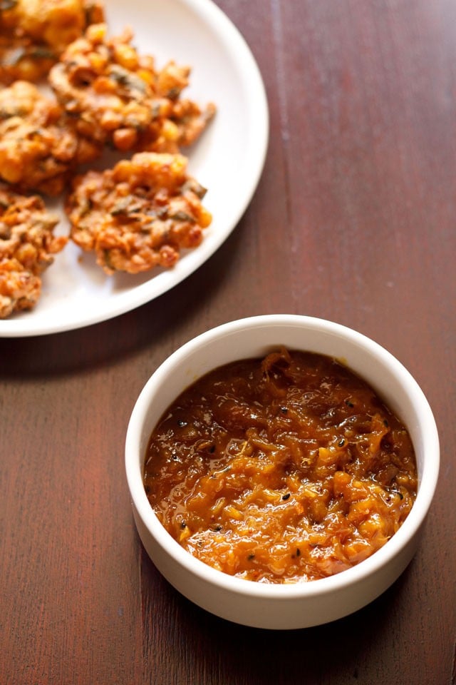 mango chutney served in a bowl with pakoras on the side