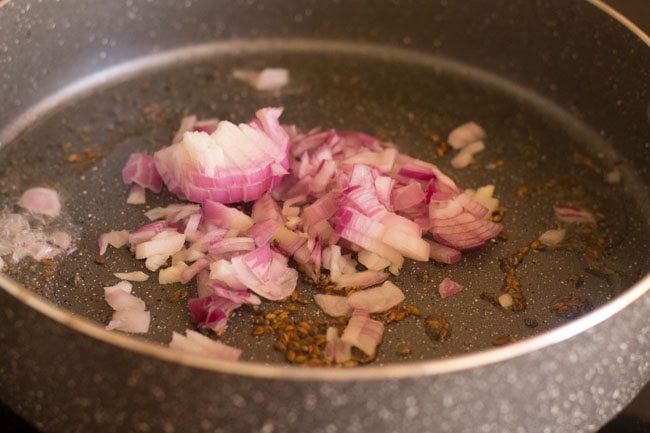 adding chopped onion to the pan