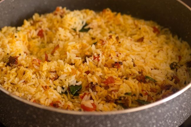 mixing cooked rice with spice mixture in the pan