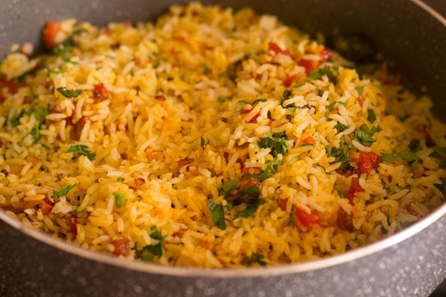 mixing coriander leaves in the masala rice 