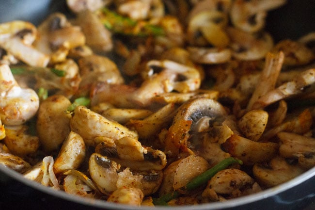 mixing spices with the mushrooms and sautéing them