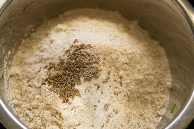 whole wheat, flour, carom seeds, green chili, hing, and salt in a large bowl