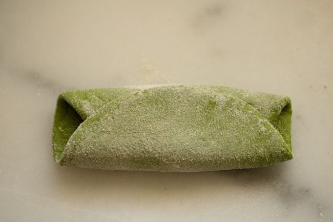 folded palak paratha dough on a board