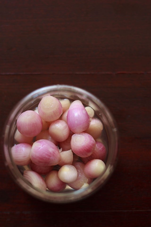 overhead shot of red pickled onions in a glass jar