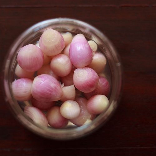 overhead shot of pickled onions in a glass jar