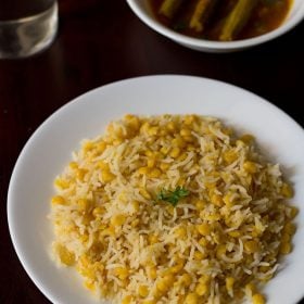 chana dal khichdi served on a white plate with drumstick curry.