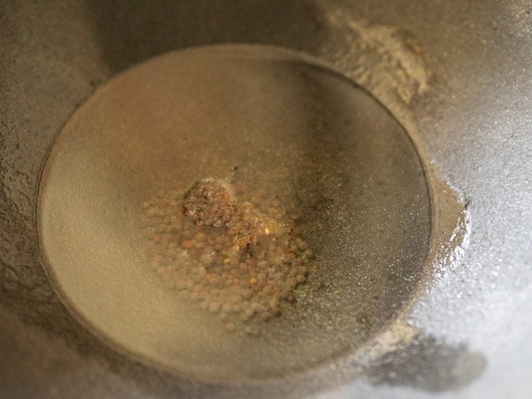 add mustard seeds to oil in a kadai