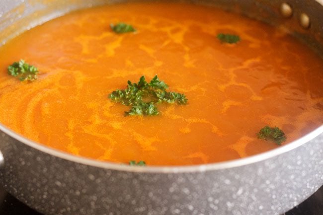 garnished carrot tomato soup with cilantro leaves