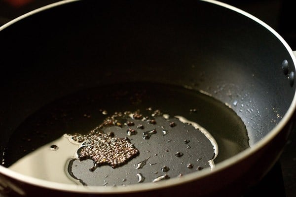 crackling mustard seeds in a pan