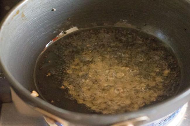 Mustard seeds and urad dal are added to the hot oil. 