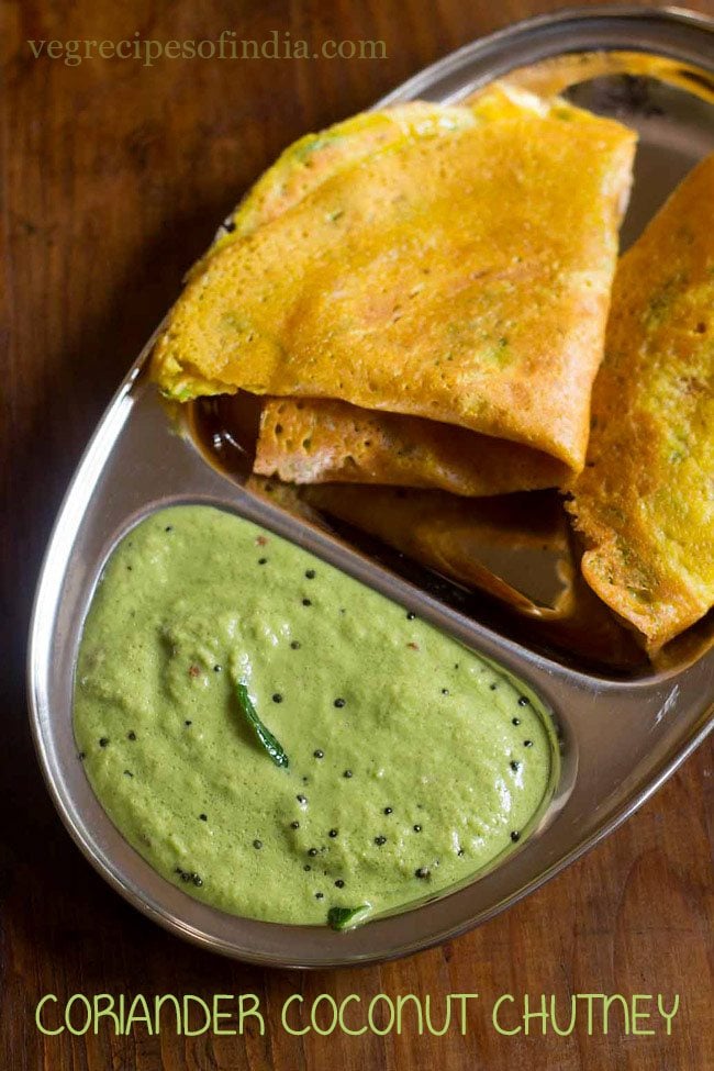 Green coconut chutney served with dosa on a plate.
